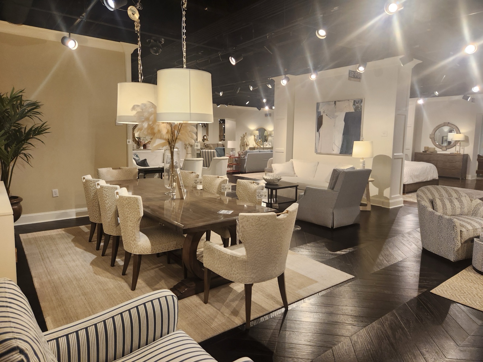 A furniture showroom with a dining table, upholstered chairs and living room seating on display