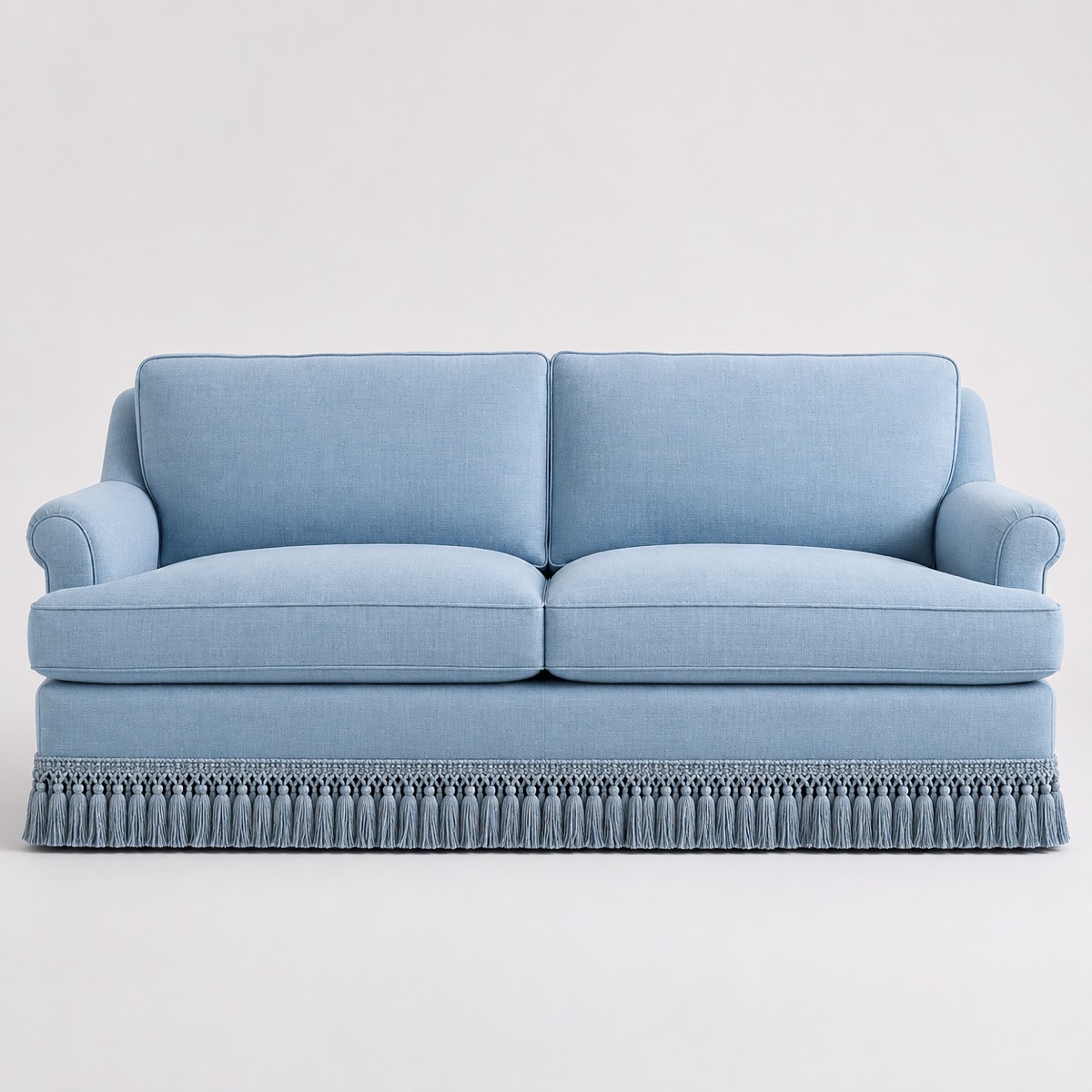 Upholstered sofa finished with decorative fringe along the base